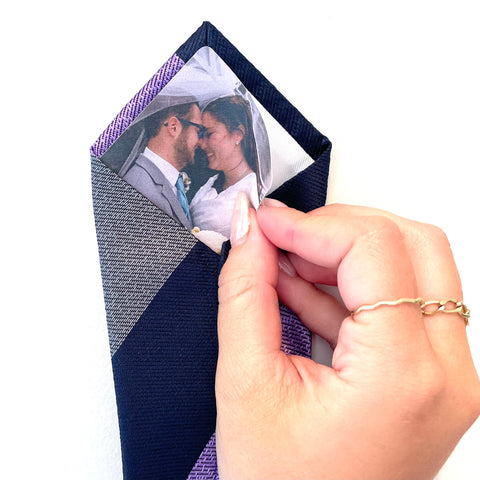 A person holding a wooden photo of a couple on a tie.