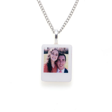 A white square pendant displaying a photo of a couple, hanging gracefully.