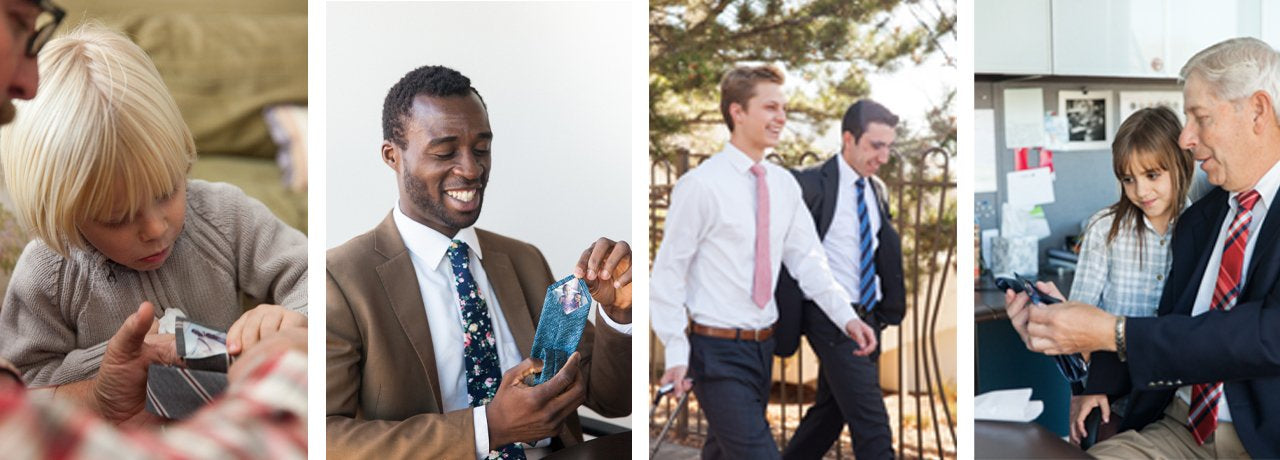 Four people in business attire, one with a child. They are wearing ties and appear professional.